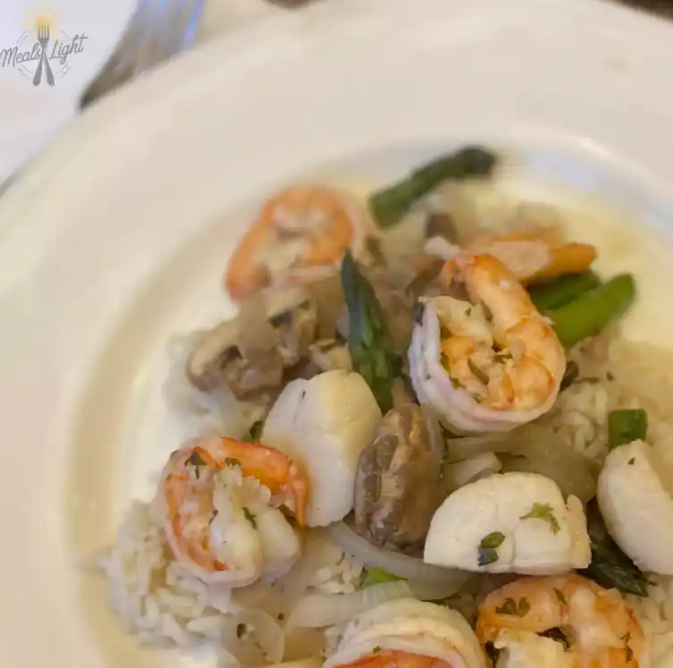 A vibrant seafood mix featuring shrimp, mussels, squid, and clams, garnished with fresh herbs and lemon slices, served on a rustic plate.